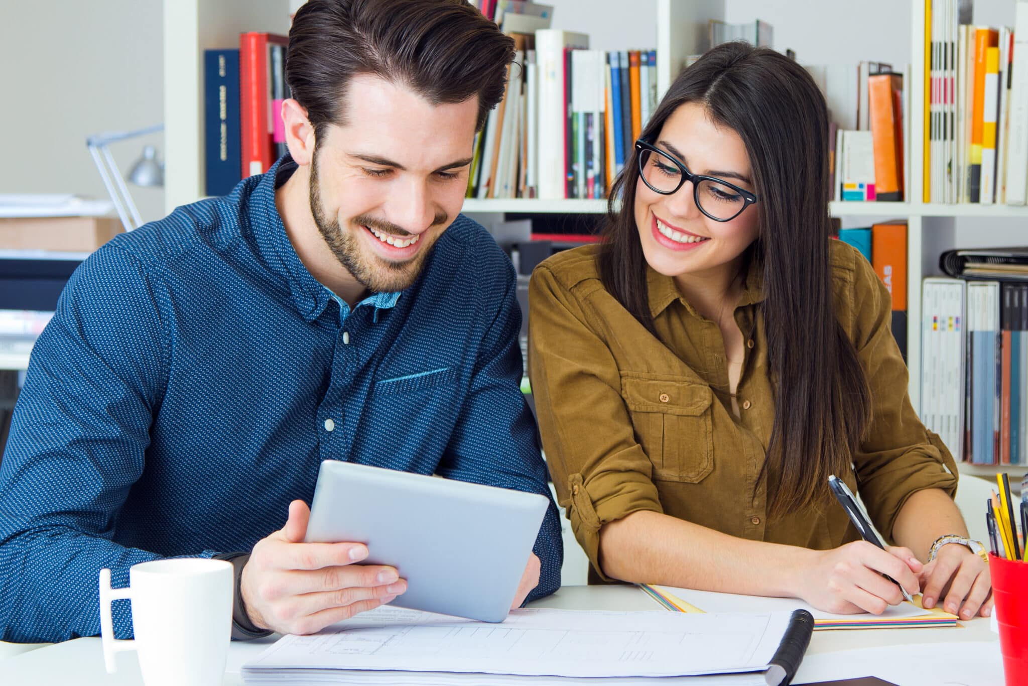 Twee medewerkers bekijken samen financiële documenten tijdens budgetcoaching